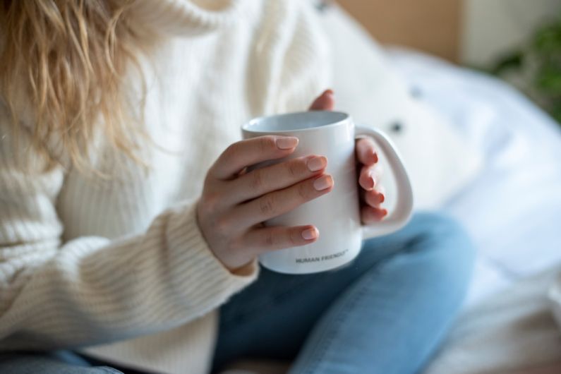 Pressure Regulator - a woman sitting on a bed holding a coffee mug
