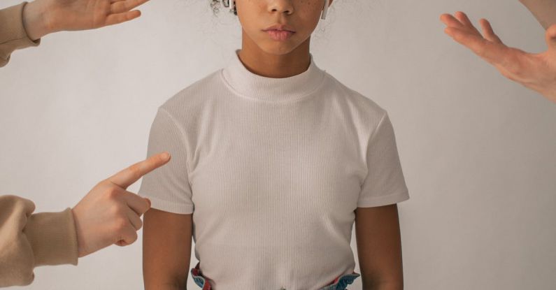 Trouble Codes - Crop people scolding disappointed African American teenage girl in casual wear standing on white background with sad face in studio