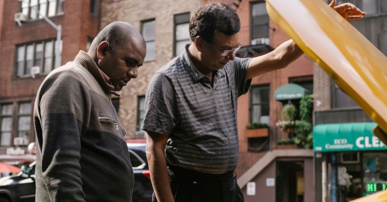 Transmission Problems - Ethnic males having problem in motor under hood of car on city street