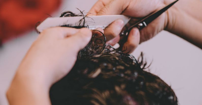 Custom Trim - From above of crop anonymous master cutting hair of male client in modern barbershop