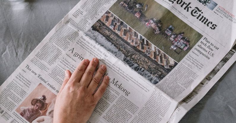 Headliner - Person Reading Newspaper On Table