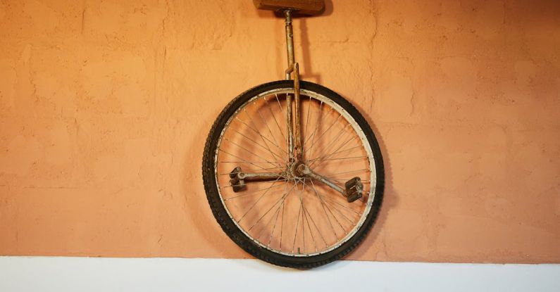 Tire Balance - Old shabby unicycle hanging on brick wall